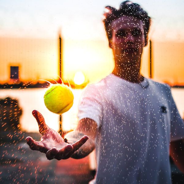 Person stretching outdoors during a sunrise, silhouette style.